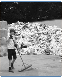 a worker sweeps recycled material